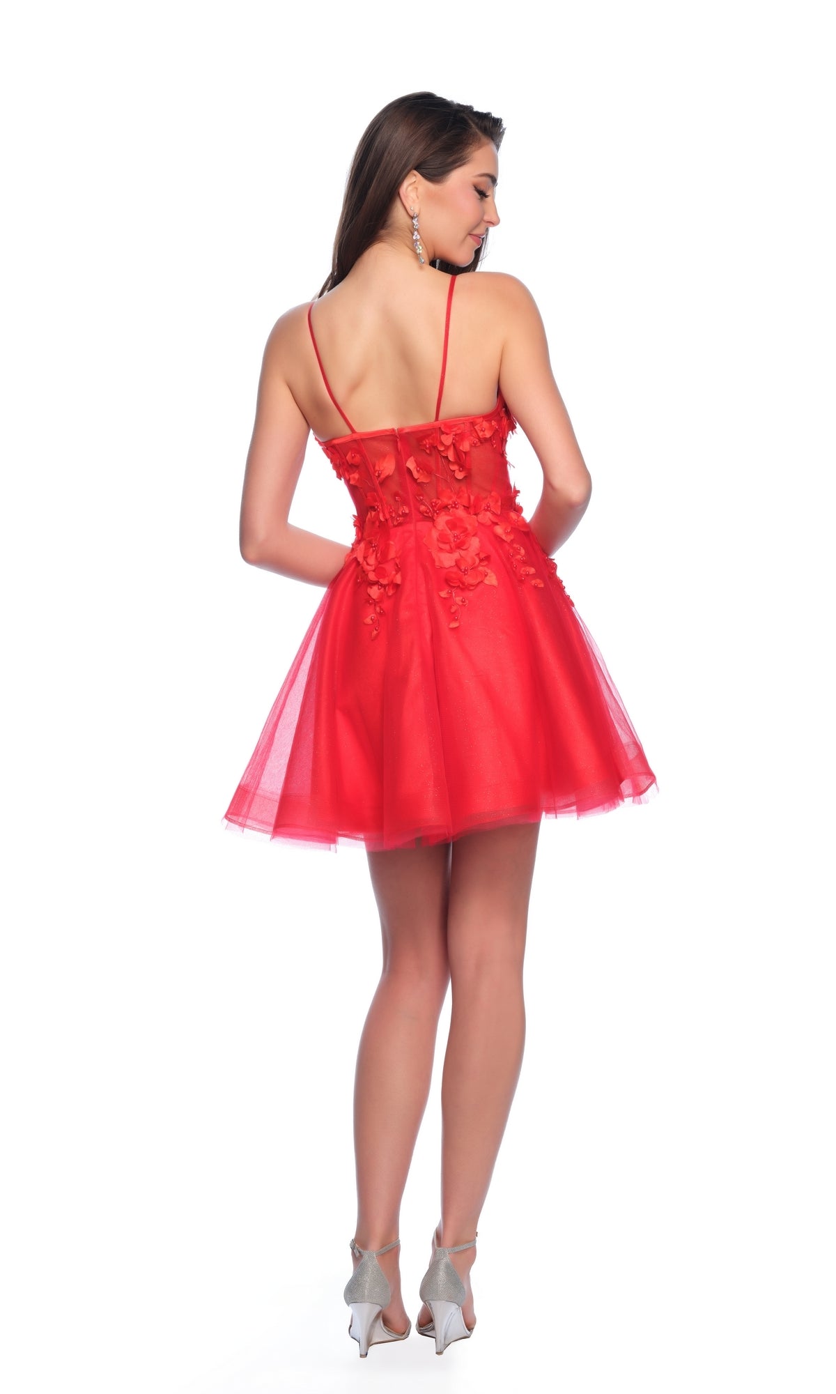 A woman models the Dave and Johnny Short Red Floral Hoco Dress 11726, featuring thin straps, floral appliqué, an open back, and a subtle corset bodice.